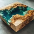 Square coffee table of rare burl wood with deep-pour turquoise epoxy resin filling a central void, showcasing preserved grain and live edges on a concrete floor.
