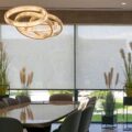 Large motorized roller shades softly filtering light in a contemporary dining room