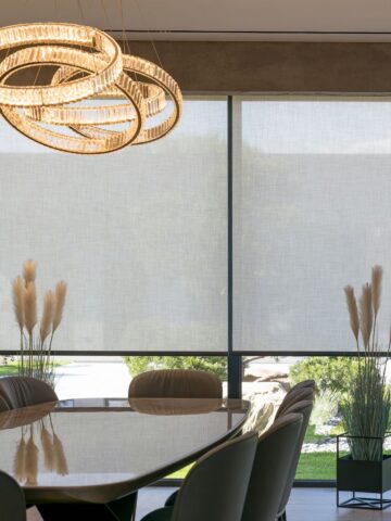 Large motorized roller shades softly filtering light in a contemporary dining room