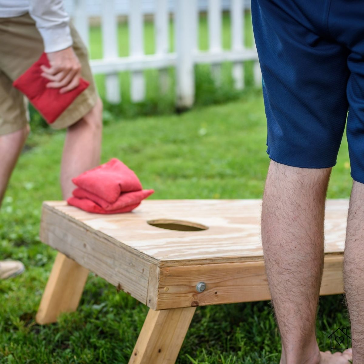 Closeup of cornhole board and bean bags on grass