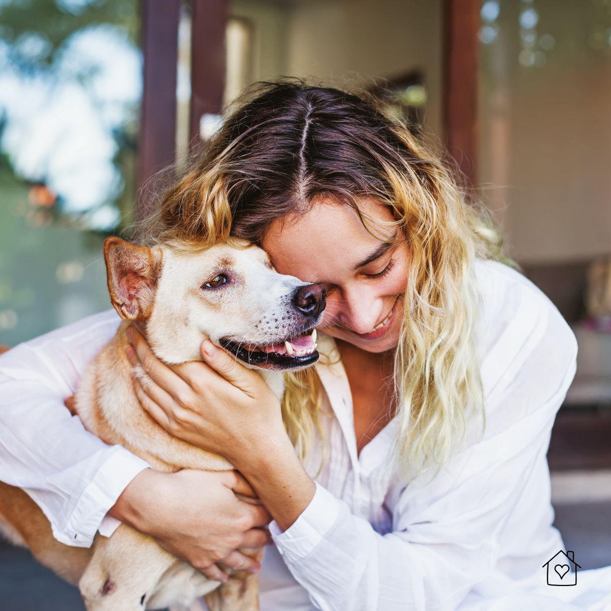 Woman hugging her happy dog after returning home.
