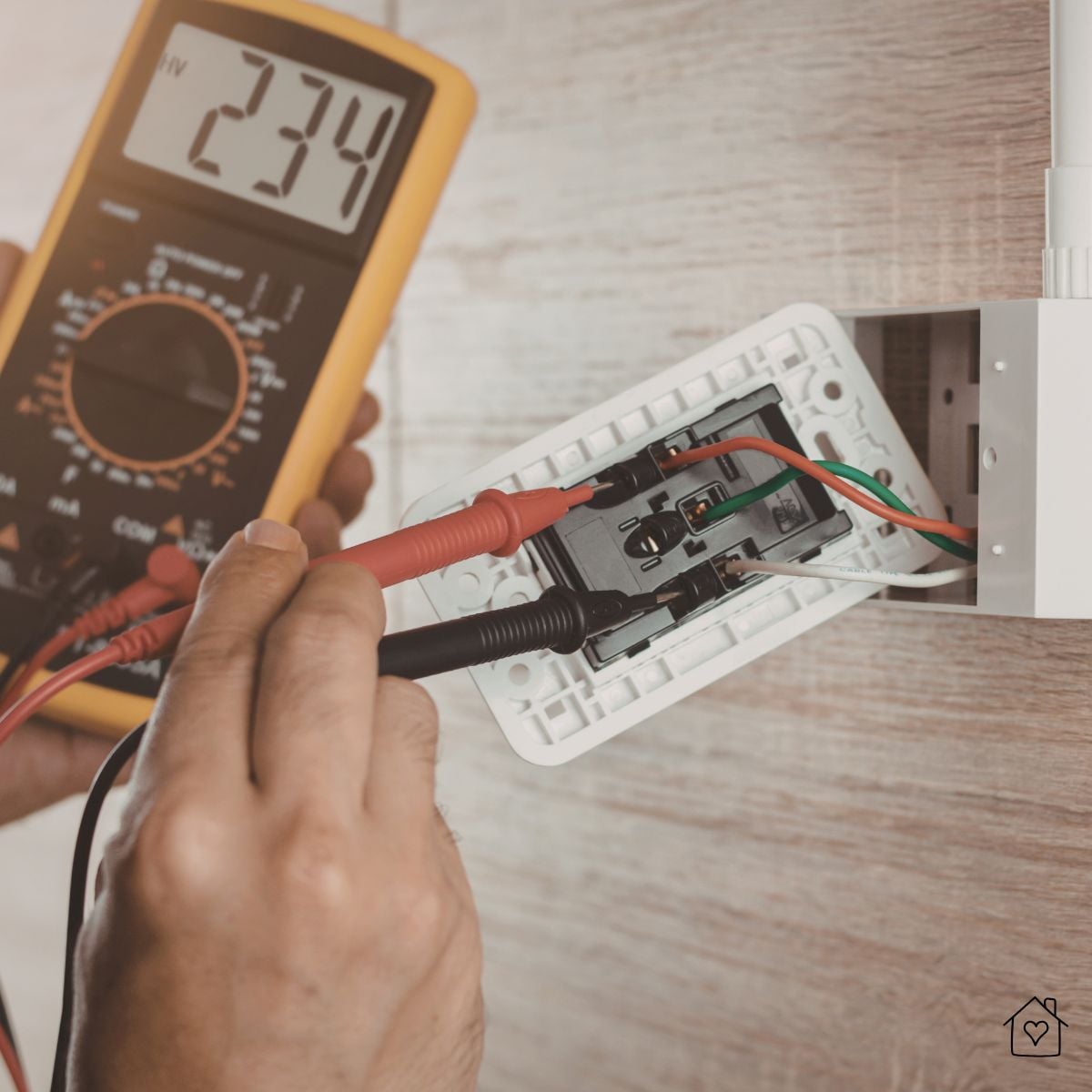 Electrician testing wiring with a multimeter during a full gut home renovation.