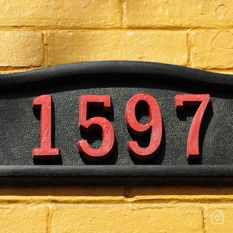Close up of elegant house numbers on a yellow brick wall