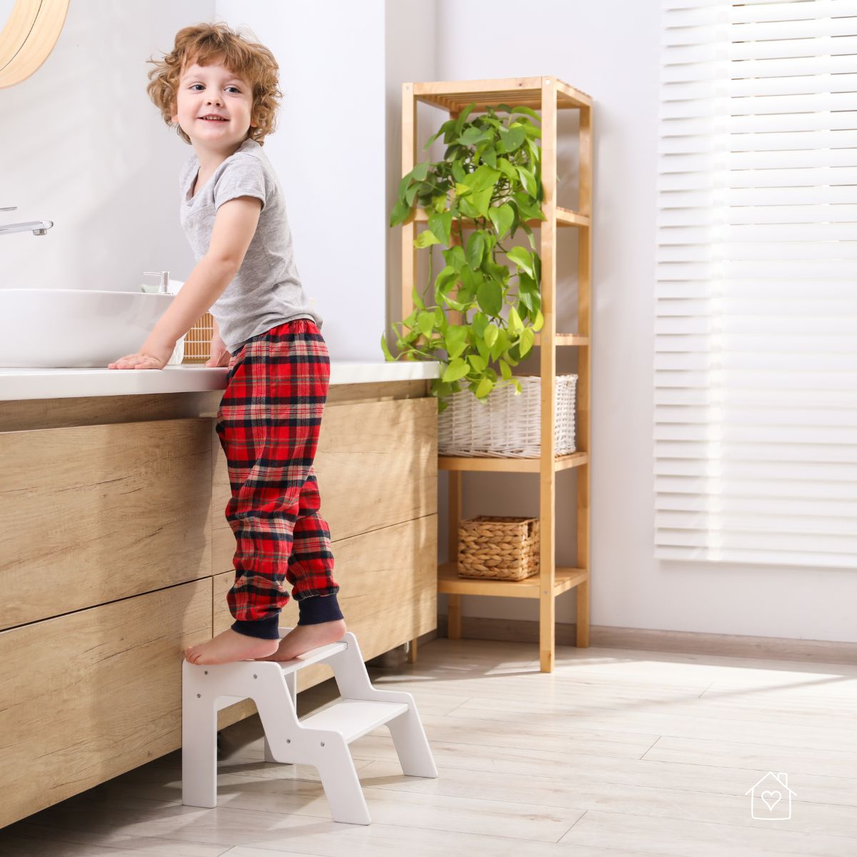 Young child using a non-slip step stool to reach the bathroom sink.