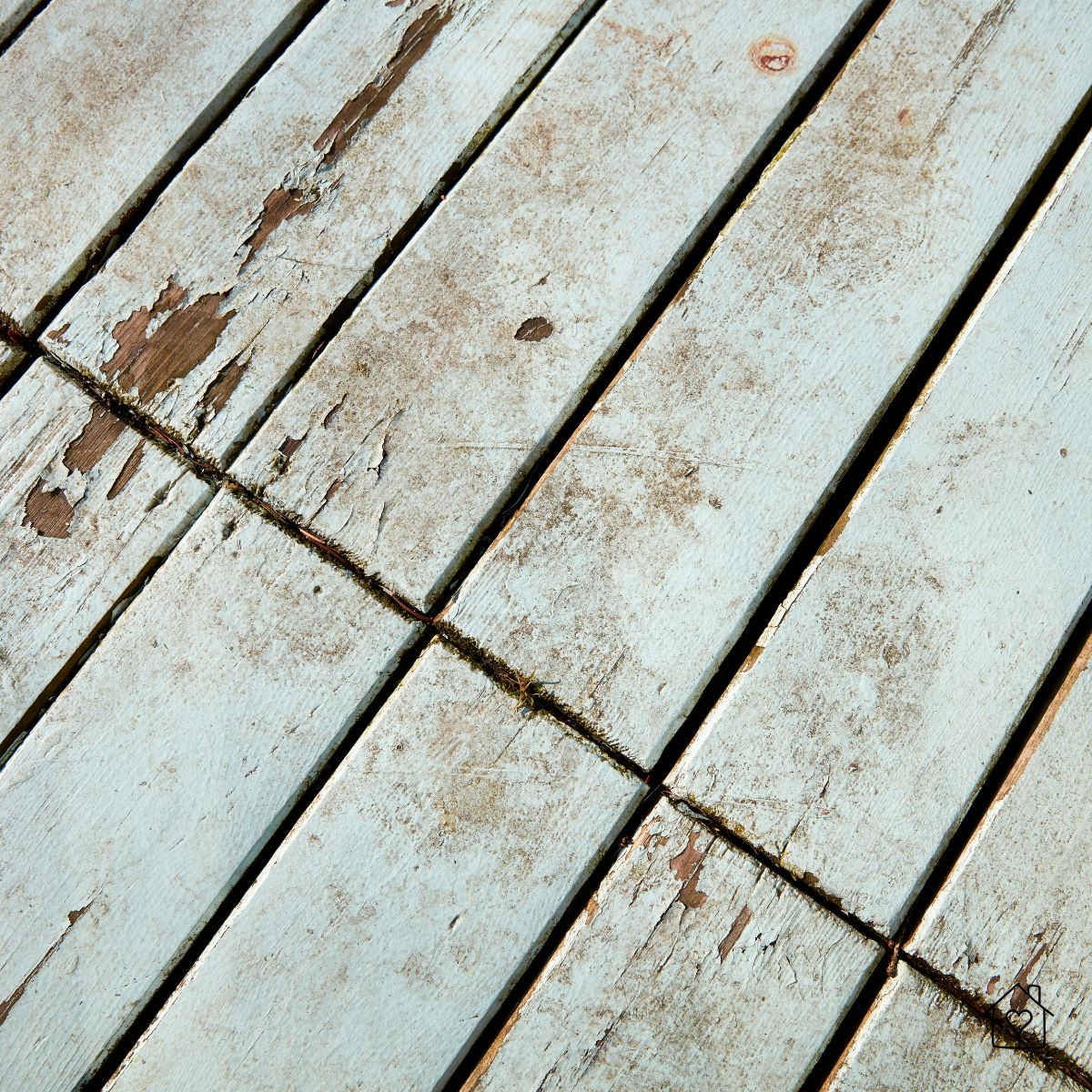 close up of peeling paint and cracked wood on an old outdoor deck