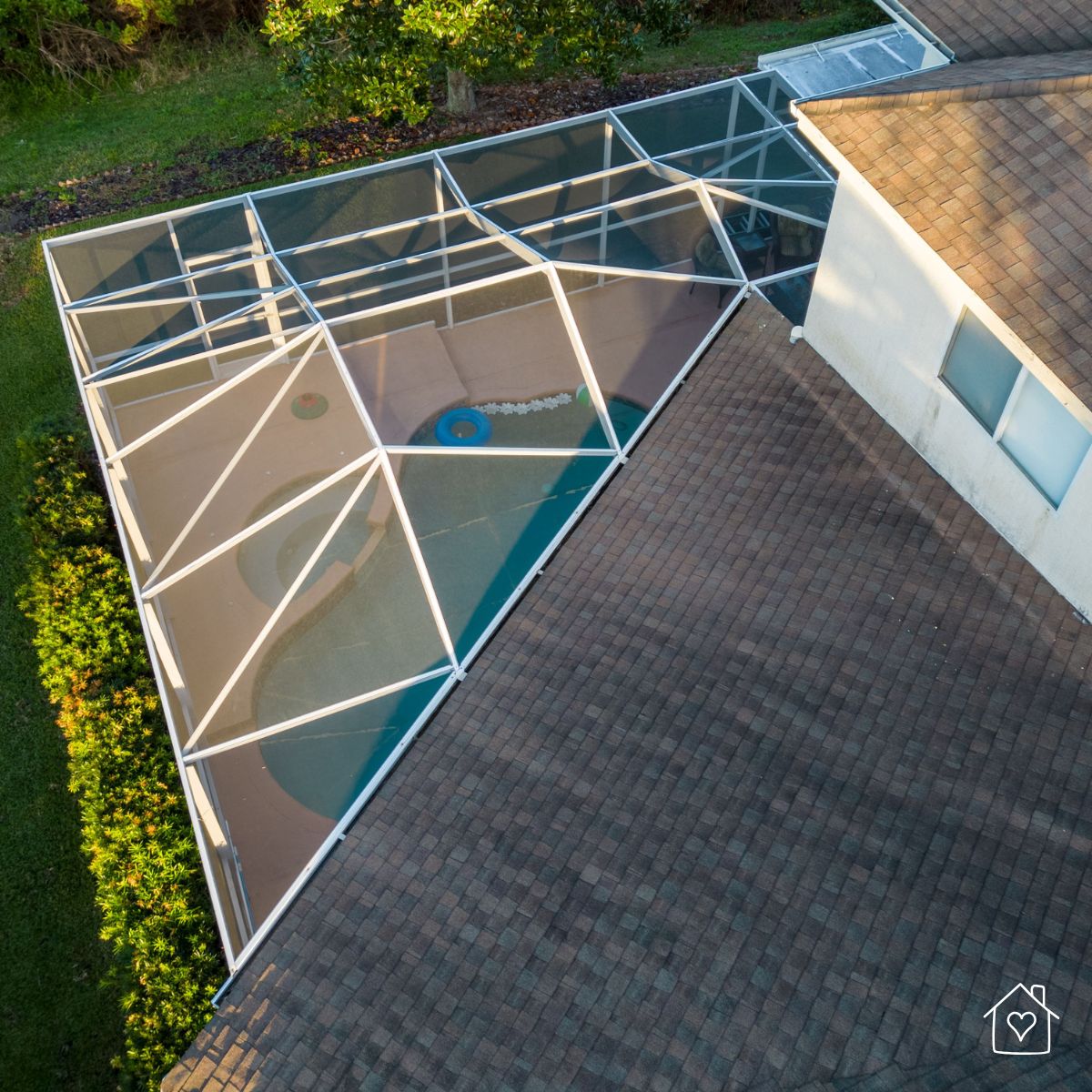 aerial view of an older pool screen cage showing aging mesh and aluminum framework