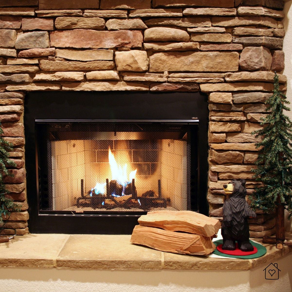 Professionally installed stone gas fireplace with safety screen in a Maryland home