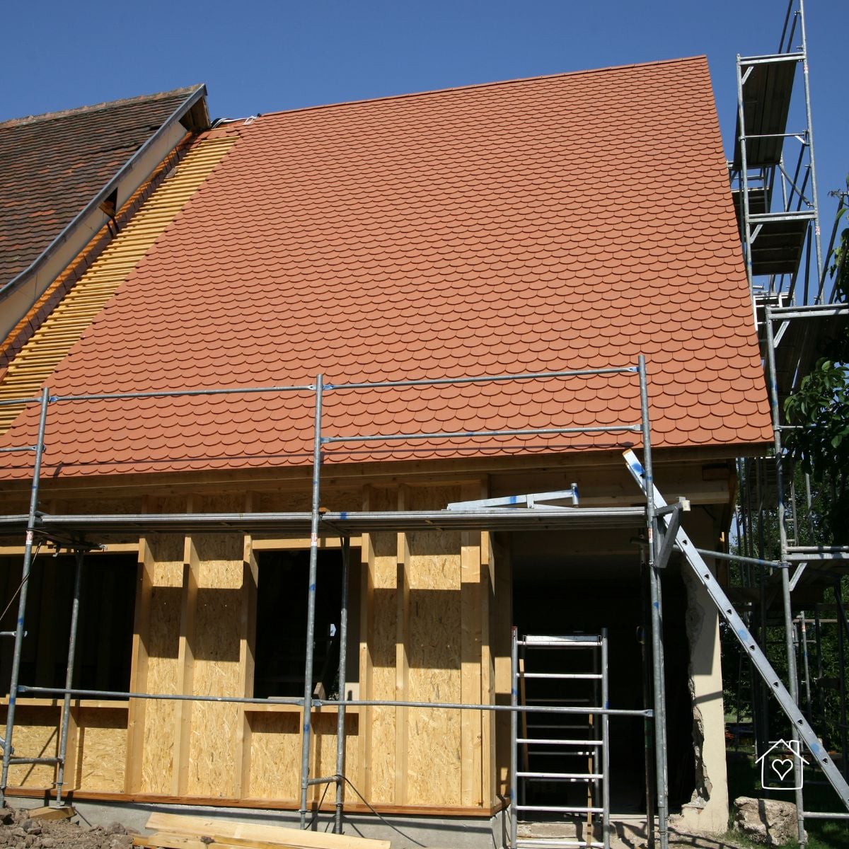 Exterior addition with new tiled roof and wall sheathing in progress.