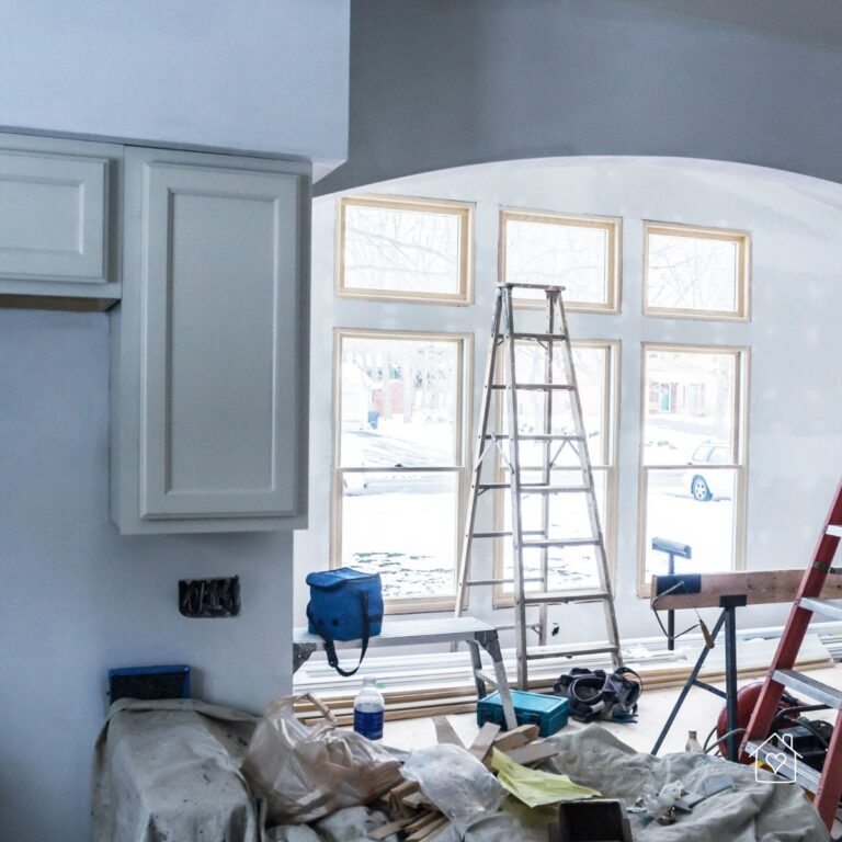 Interior of a home addition at drywall stage with new floor-to-ceiling windows.
