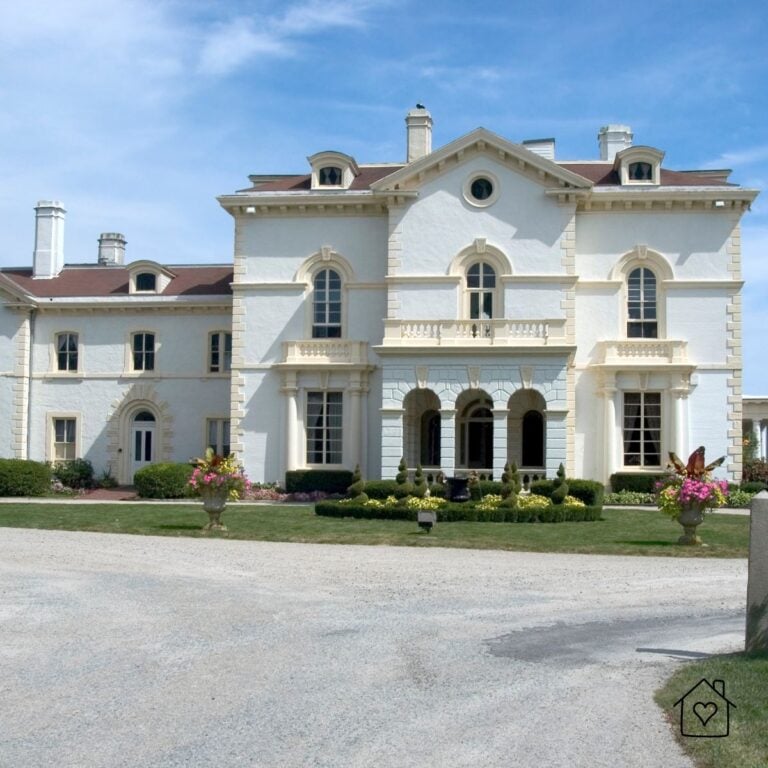 White stucco luxury home with arched European-style windows and slim profiles, showcasing refined, symmetrical fenestration.