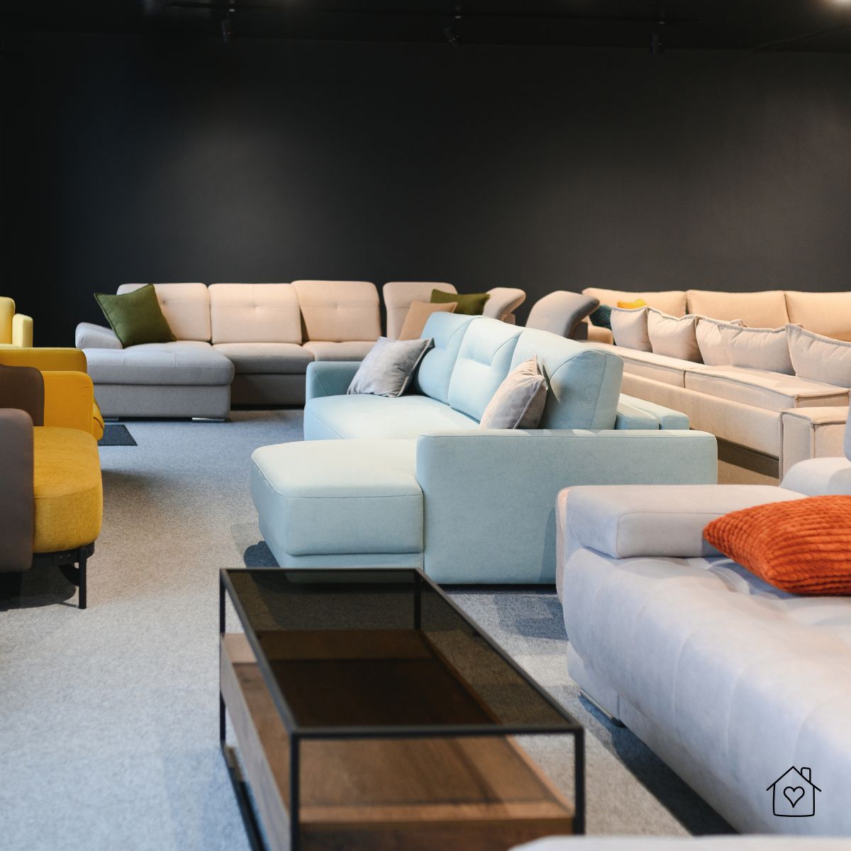Modern furniture showroom with several sofas and sectionals arranged in different styles and colors.