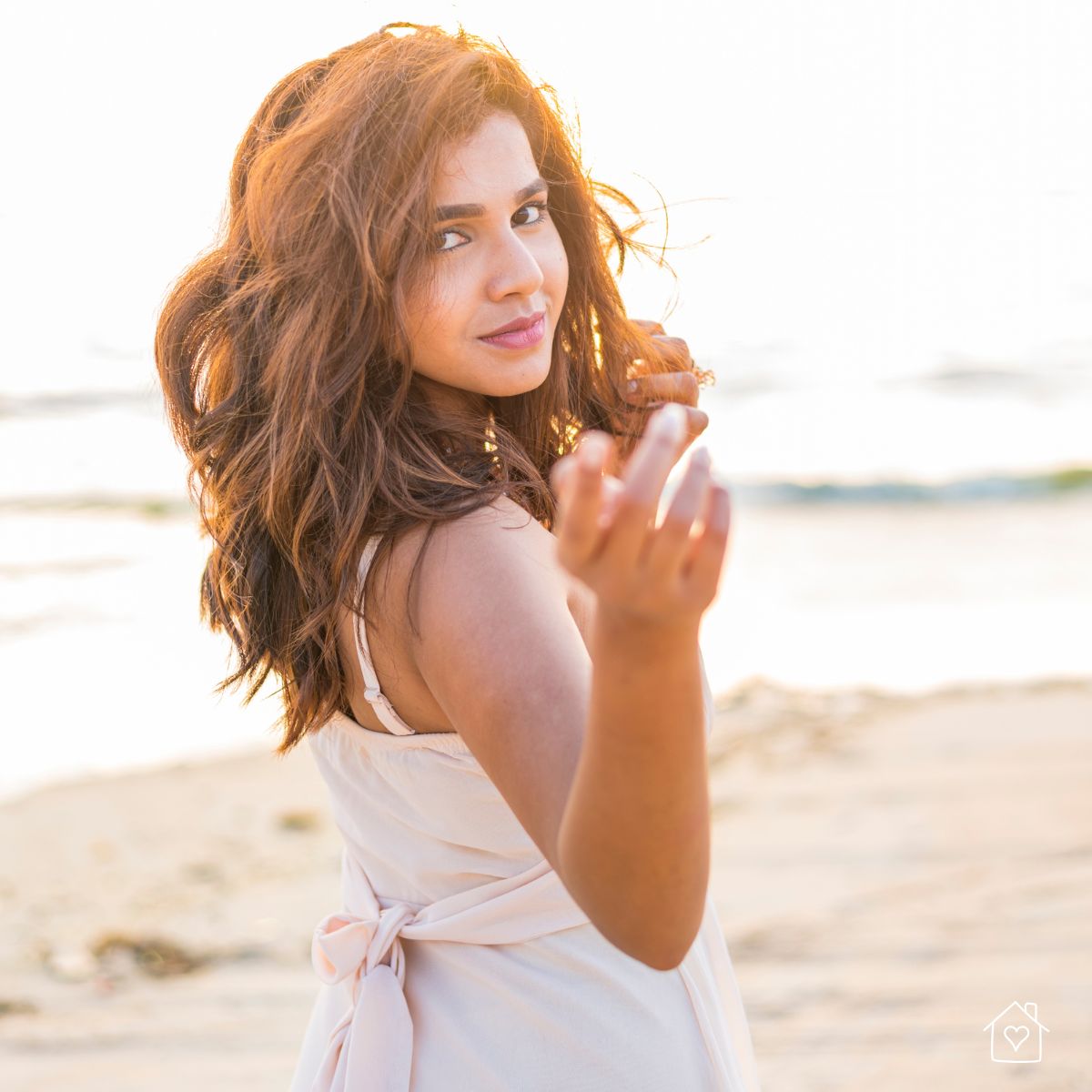 soft backlit portrait of woman reaching toward the camera with warm golden light for a romantic photoshoot mood