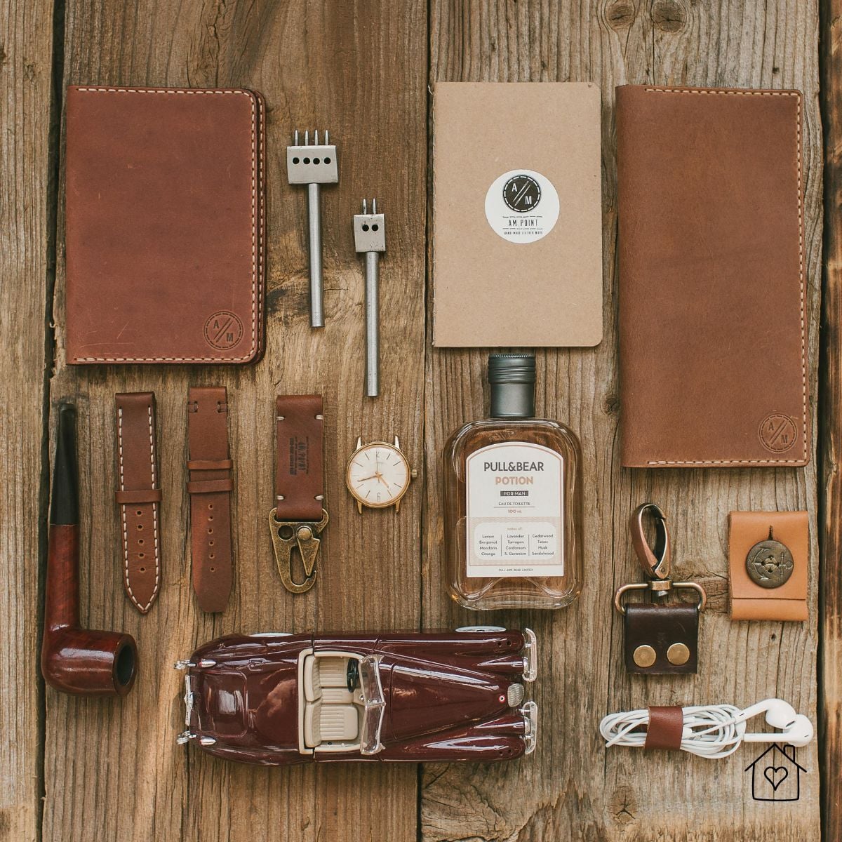 Flat lay of handmade leather accessories on rustic wood, including wallets, watch straps, notebook cover, and small everyday carry items.