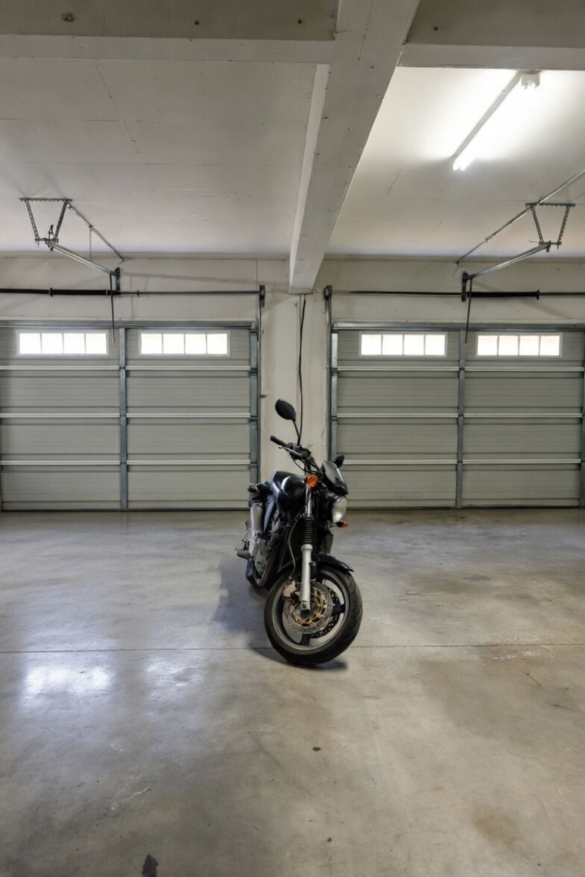 Clean, cleared garage with open floor space and a motorcycle in the center after removing clutter and organizing the area.