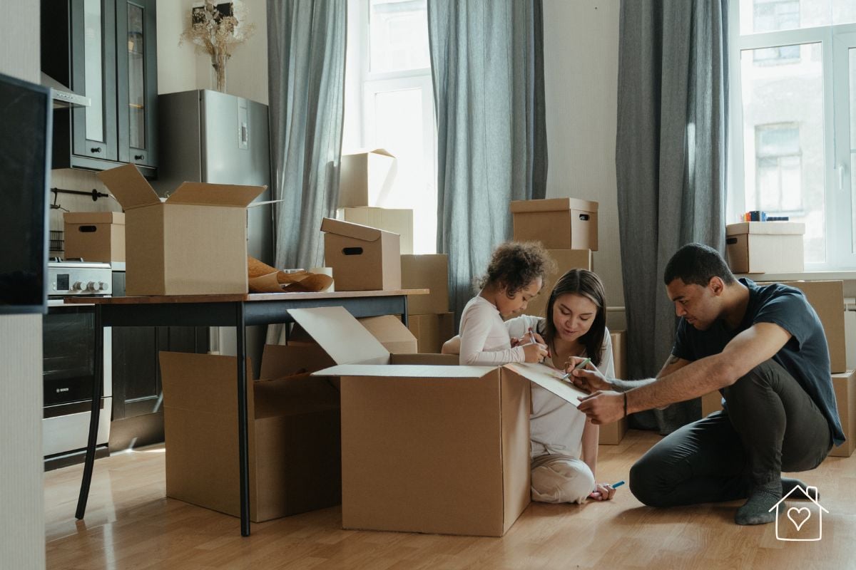 Family sitting among moving boxes while packing and organizing for a move