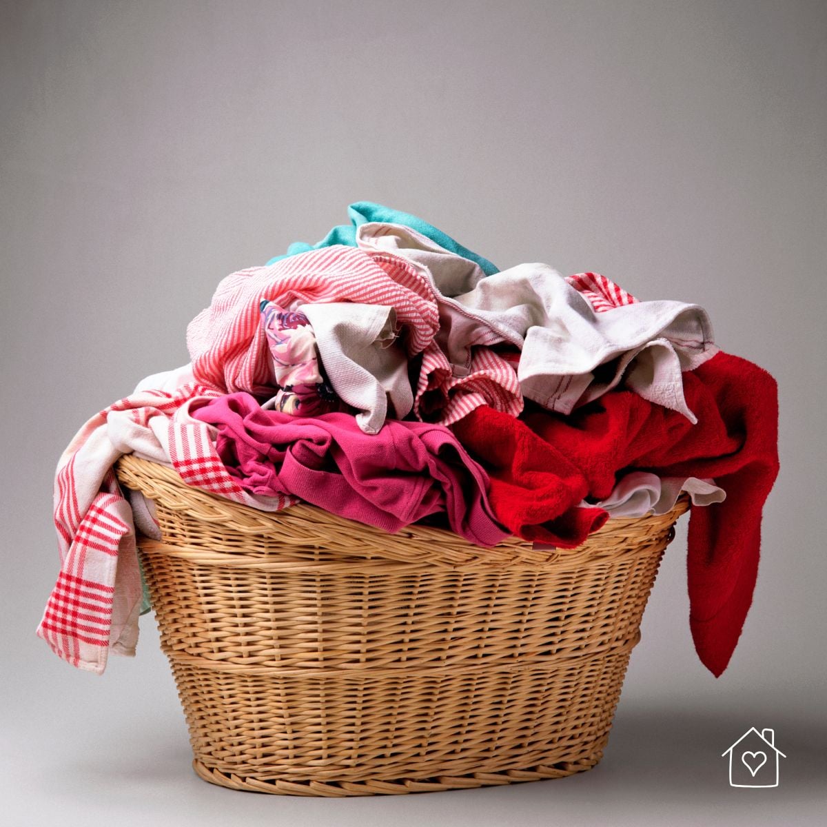 wicker laundry basket filled with laundry waiting to be folded