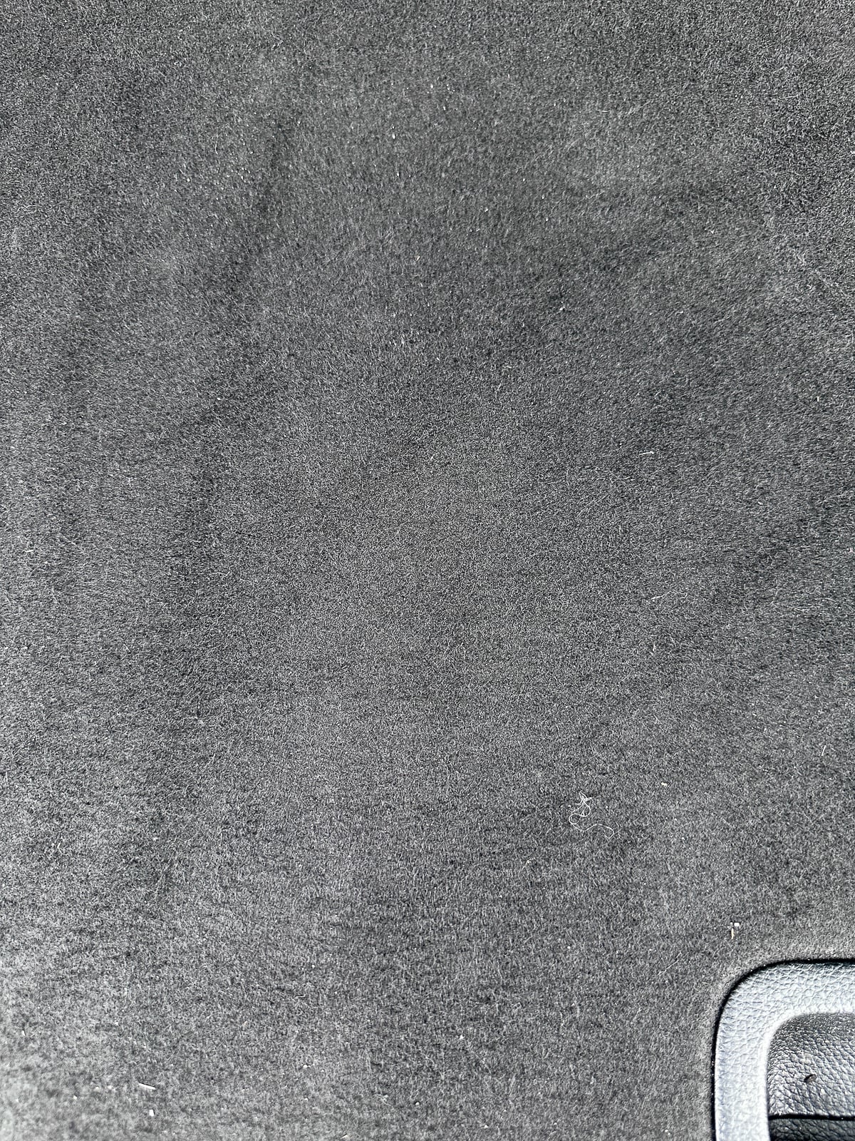 Clean black car cargo area after using the FEPPO cordless vacuum to remove sand, dust, and debris.