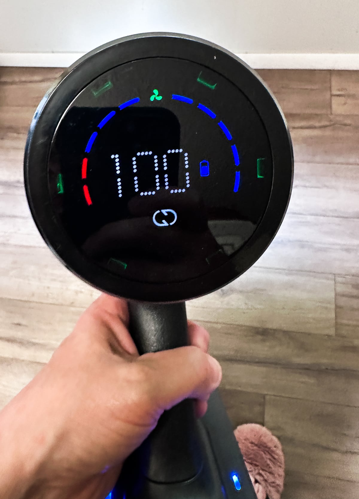 Close-up of the FEPPO cordless vacuum LED display showing battery level and cleaning mode while in use.