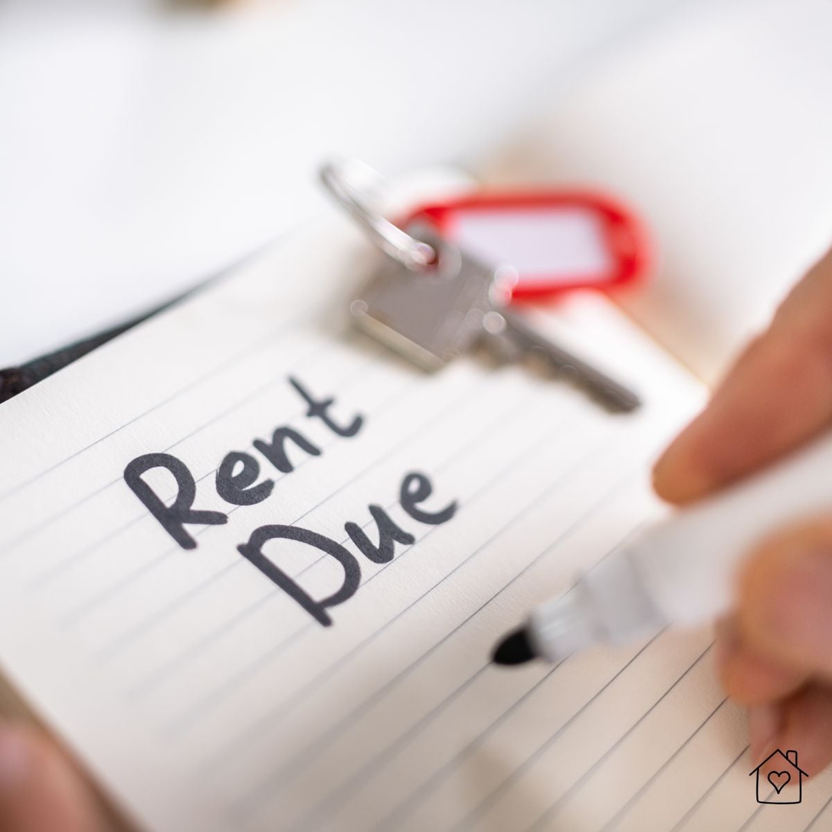 Lined tablet paper with a key and the phrase Rent Due written in bold black marker