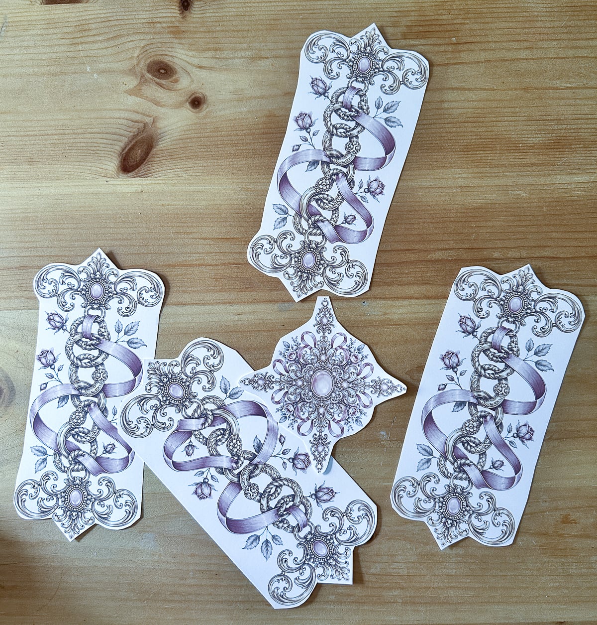 Cut sublimation transfer pieces, four gold and pink connectors and one center medallion