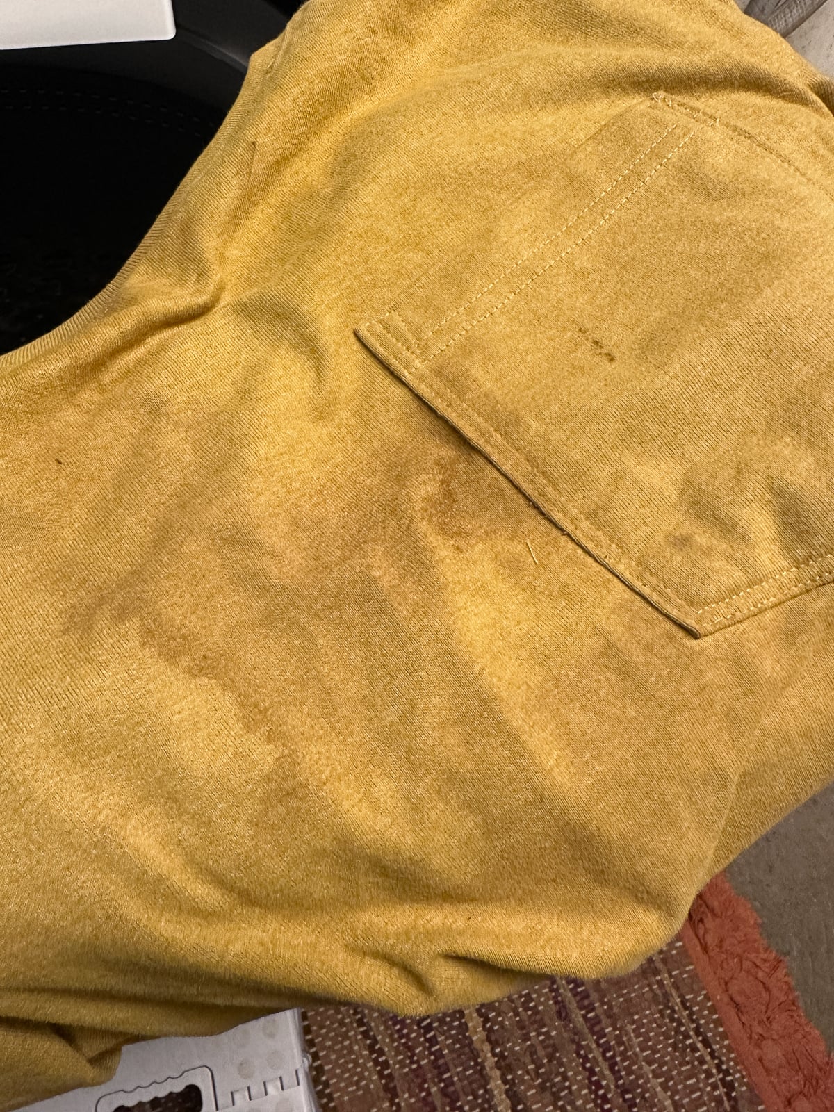 Mustard yellow shirt covered in mud stains from yard work and landscaping in the rain