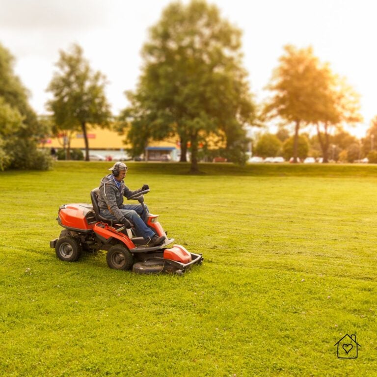 Man operating a riding lawn mower in straight overlapping lines across an open lawn