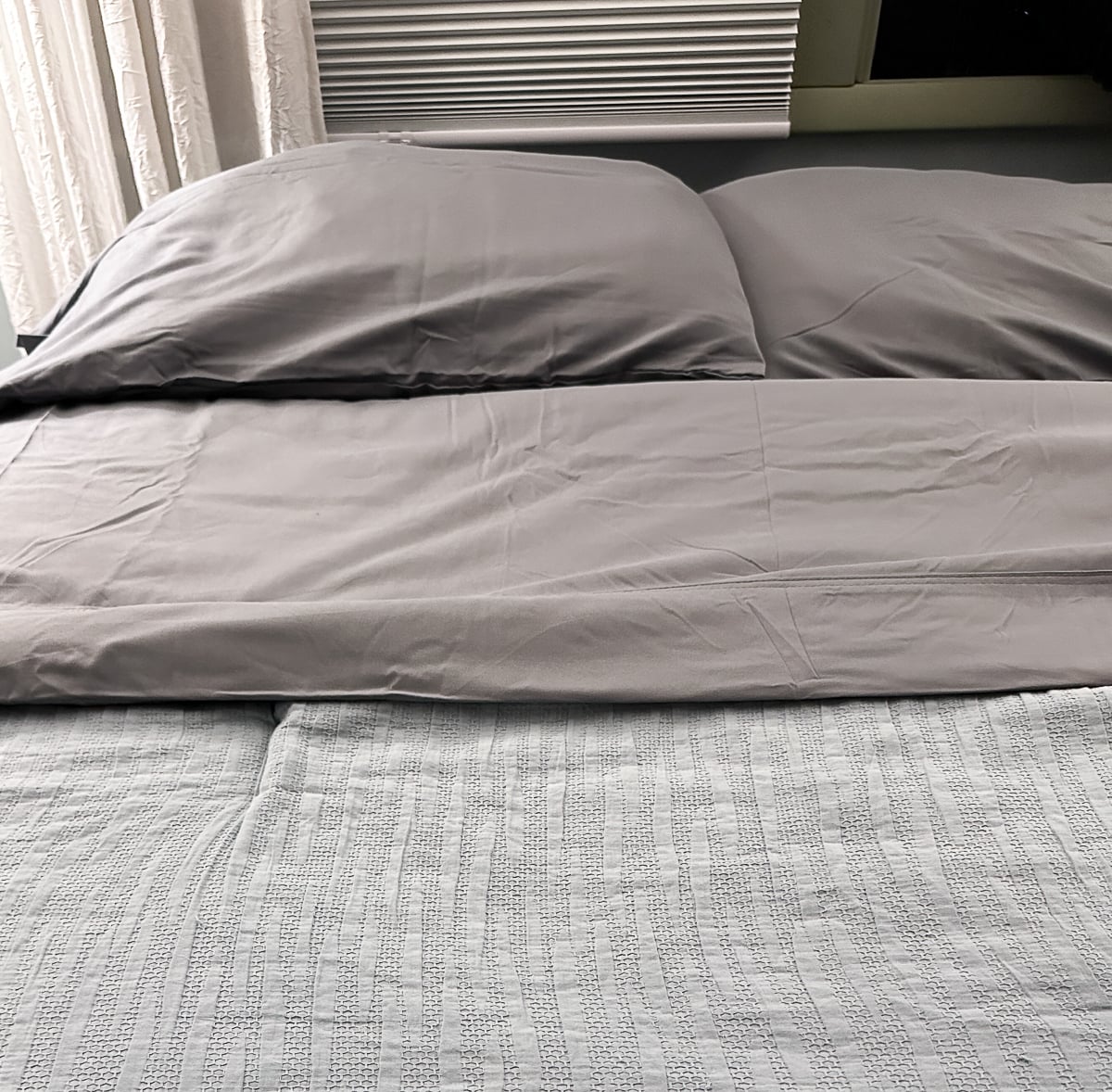 Cooling gray sheets on a made bed, a simple upgrade for hot sleepers