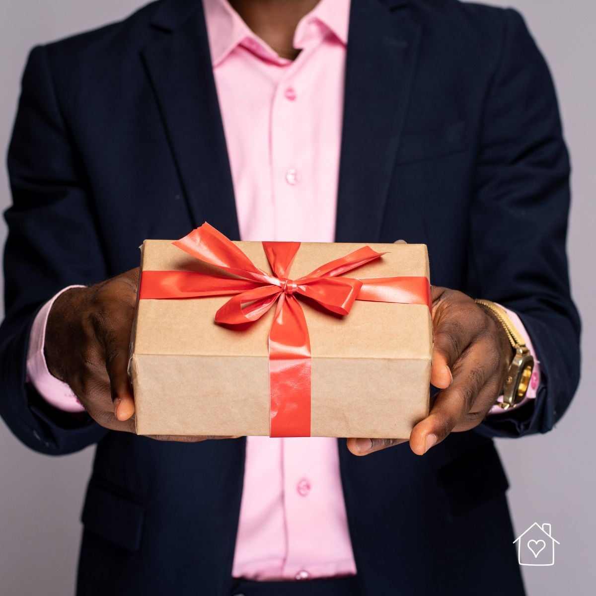 Wrapped gift idea for the man who has everything, tied with a red ribbon