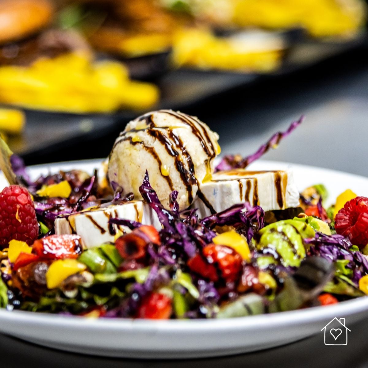 Mixed greens topped with goat cheese, raspberries and purple cabbage, drizzled with thick balsamic glaze
