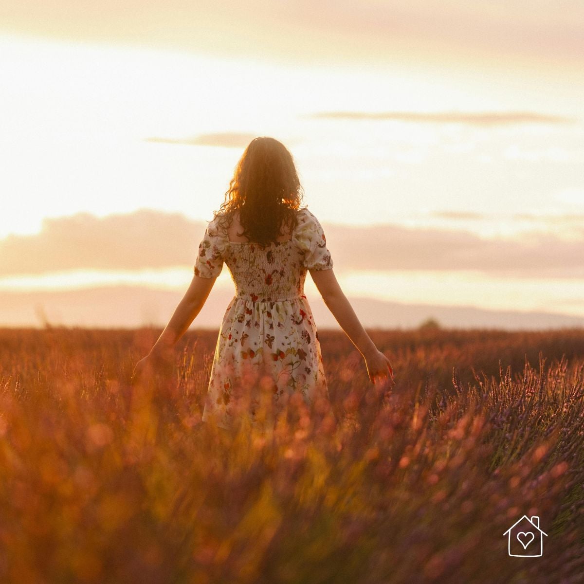 Woman walking through a field at sunset with arms relaxed, taking a quiet mental rest break outdoors