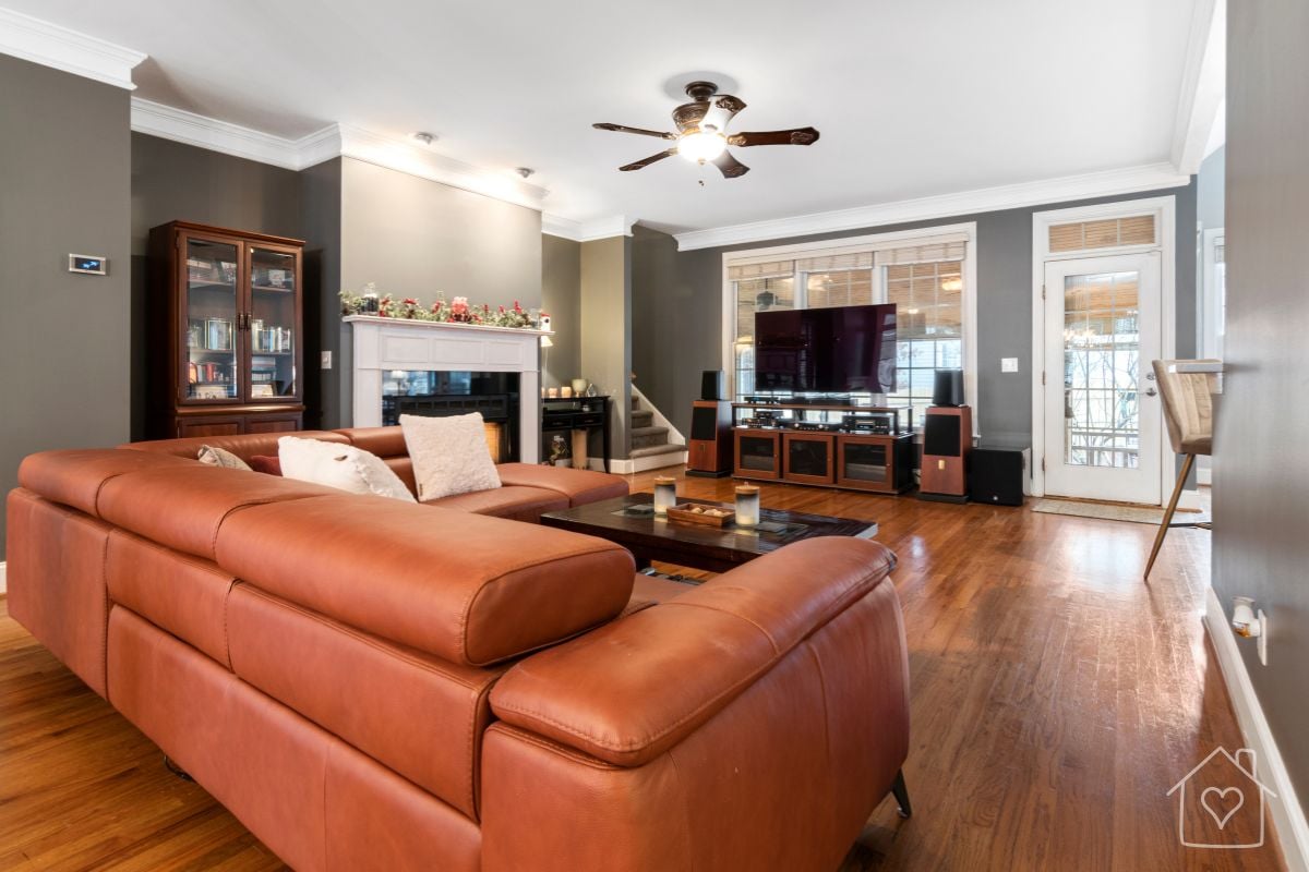 Cognac leather sectional sofa in a cozy family living room with hardwood floors and a fireplace