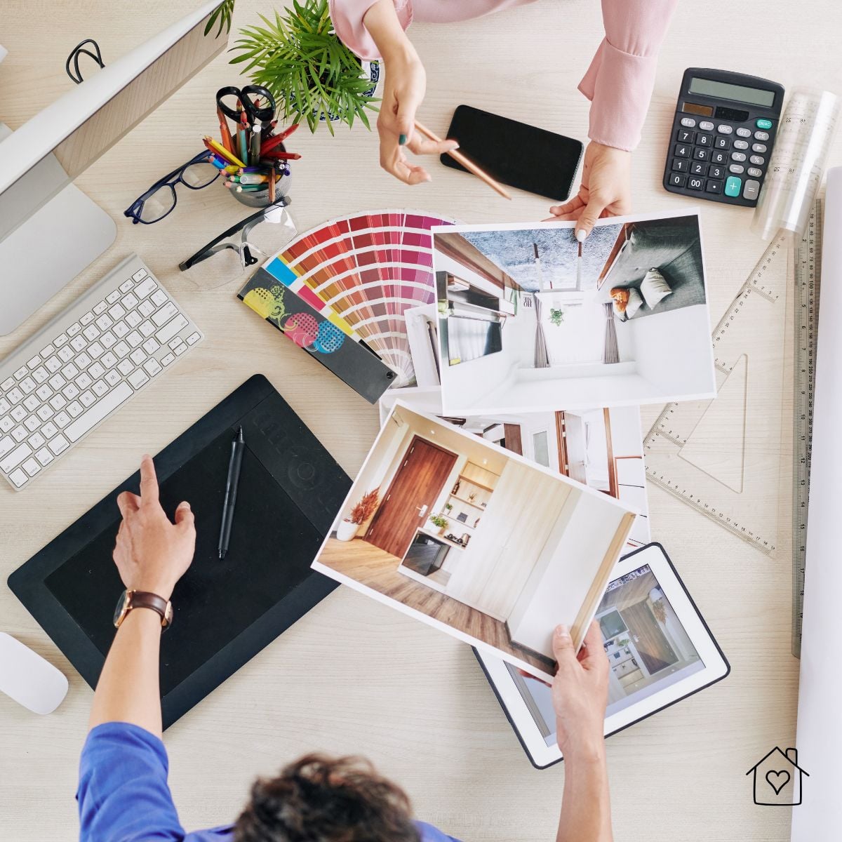 Overhead view of a workspace with room design photos, color swatches, a calculator, and planning tools.