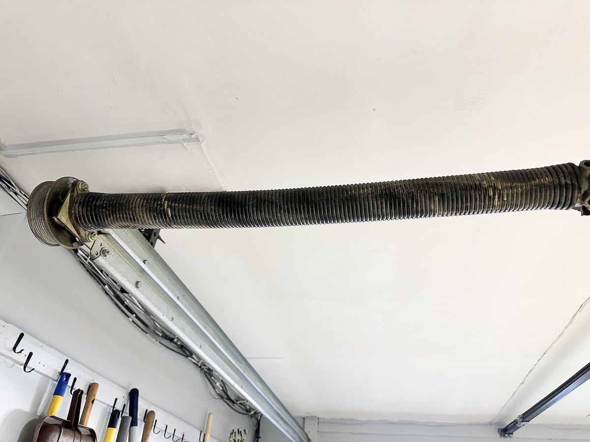 Torsion spring mounted above a garage door, a part only a technician should handle